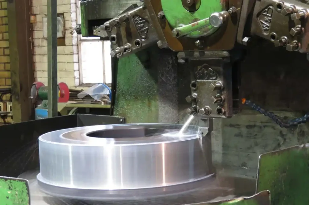 Pipechem vertical boring mill machine precision machining a large industrial steel flange with coolant spray